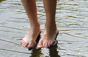 Bare feet standing in water